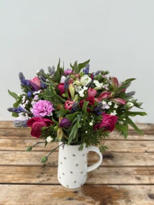Fresh cut flowers. Hand-Tied Seasonal Bouquet - 100% British in April. Bouquet features Scillas, Tulips, Alstroemeria, Scented Pinks and Ranunculus. Vase not included.